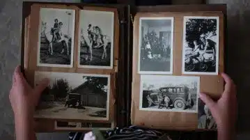 person opening photo album displaying grayscale photos