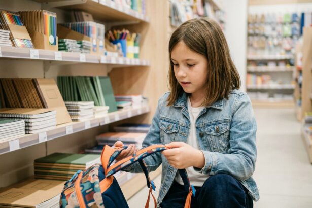 Jeune fille choisissant un sac à dos dans un magasin de fournitures scolaires pour la rentrée